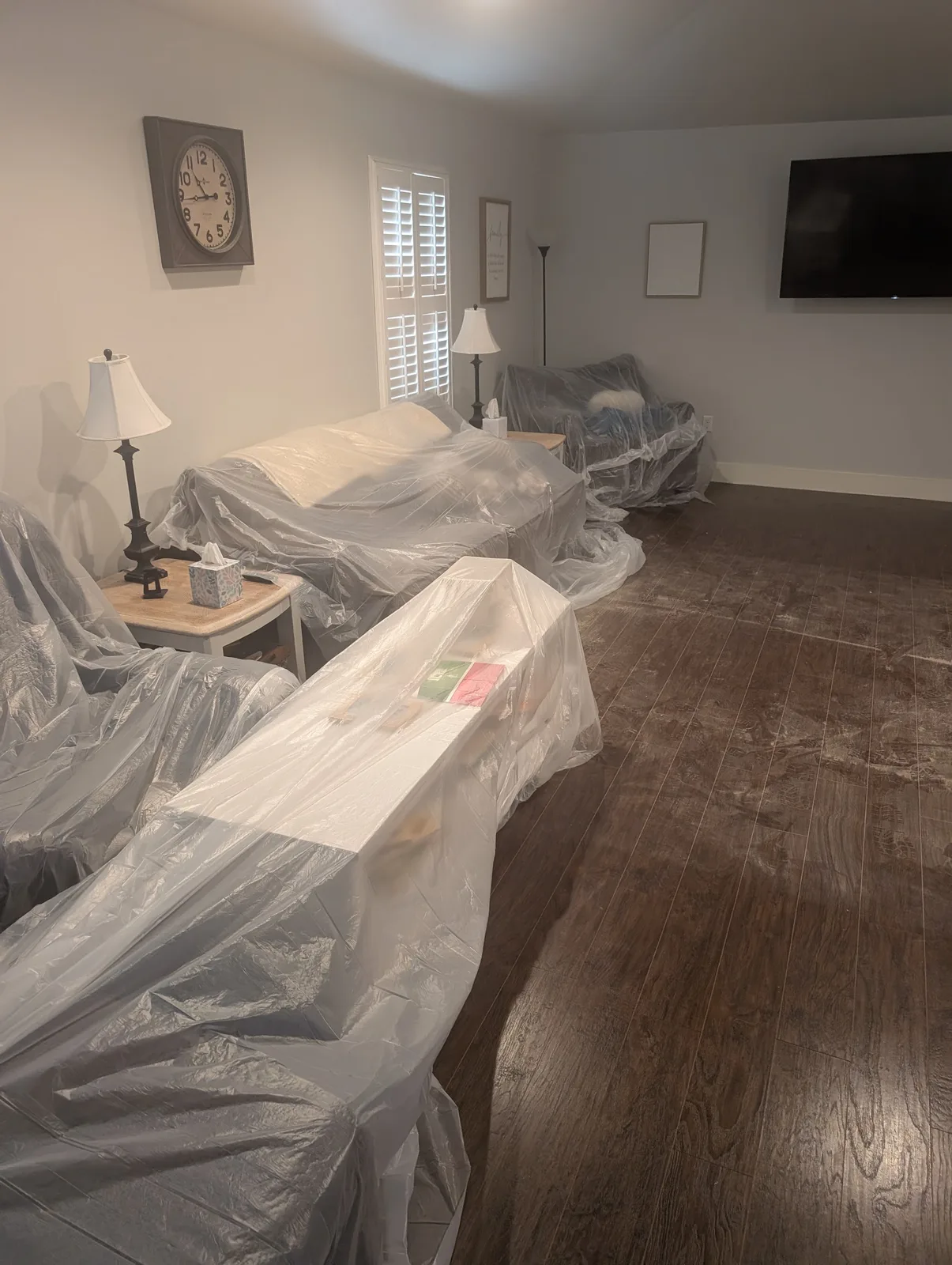 Furniture and belongings wrapped in protective poly sheeting during fire restoration work