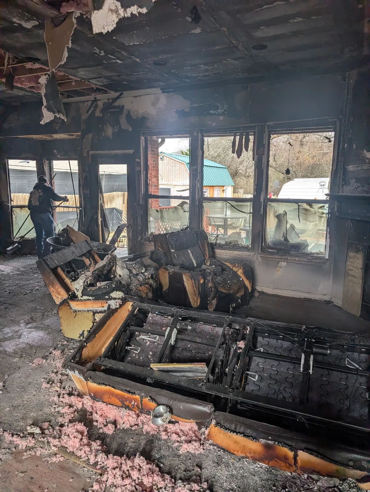 Warrior Restoration technician working in a fully gutted fire-damaged living room