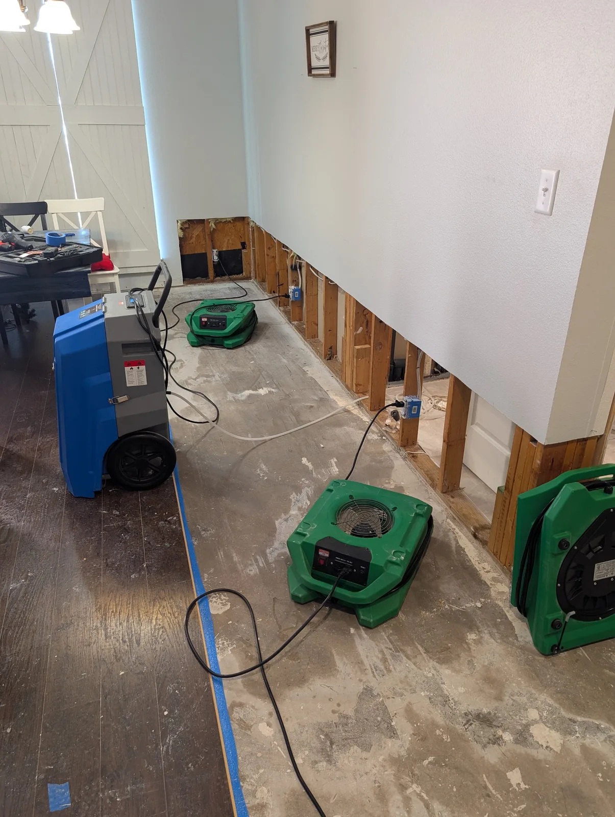 Warrior Restoration crew mid-mitigation, flood cuts and air movers in a North Texas home